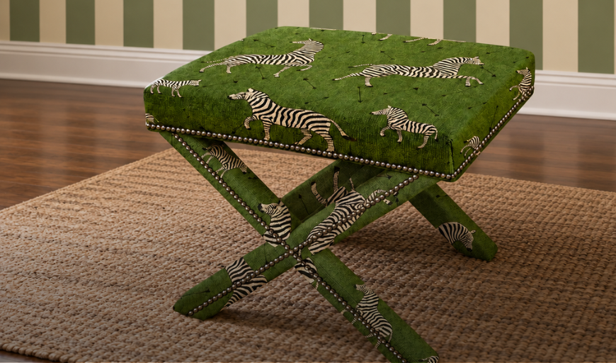 Banqueta estofada em tecido verde com estampa de zebras.